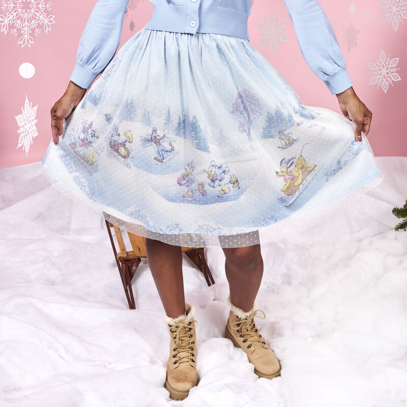 Woman wearing the Stitch Shoppe Mickey and Friends Winter Snow Tulle Overlay Skirt against a wintery background